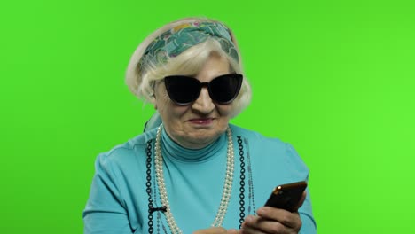 Elderly-stylish-caucasian-grandmother-woman-using-social-media-app-on-smartphone