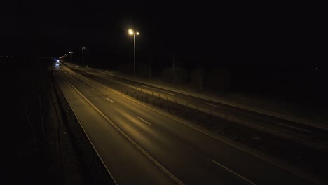 vehicles at highway filmed from a bridge from the side by night