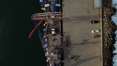 aerial top down of military ship buque escuela with waving flags during sunny day