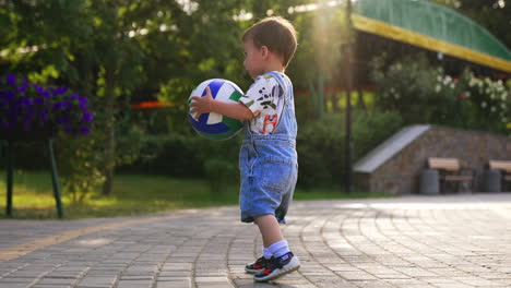 toddler playing with a volleyball in a park