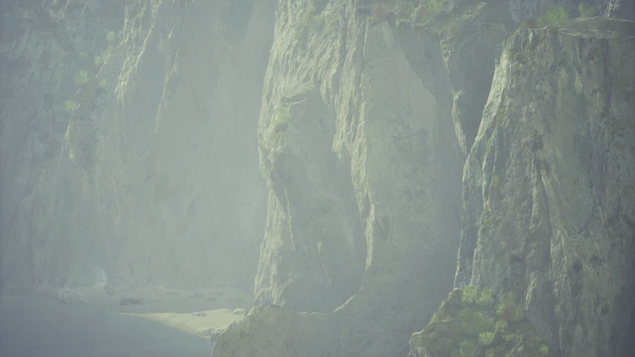 Majestic cliffs rise above a serene beach under misty skies near the coast