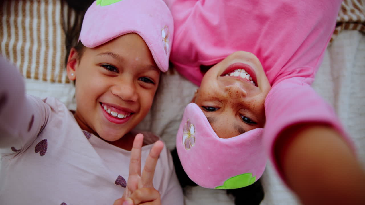 Two girls in pajamas and sleep masks taking a selfie
