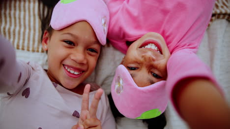 two girls in pajamas and sleep masks taking a selfie