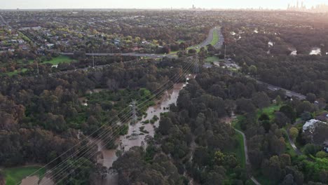 aerial view over the yarra flats park inundated with flood water on 14 october 2022, with the eastern freeway and melbourne city skyline in the background