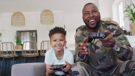Glücklicher-Afroamerikanischer-Vater-Und-Sein-Sohn-Sitzen-Auf-Dem-Sofa-Und-Spielen-Videospiele