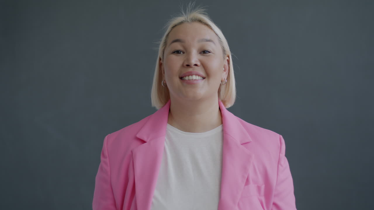 Glad kvinde i lyserød blazer