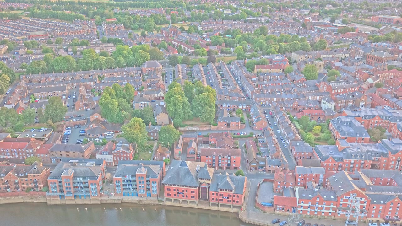 Il fiume Foss confina con il quartiere di Fishergate con edifici in mattoni rossi, case a schiera, strade alberate e sviluppo lungo il fiume, York, North Yorkshire, Inghilterra, ripresa in ascesa con drone