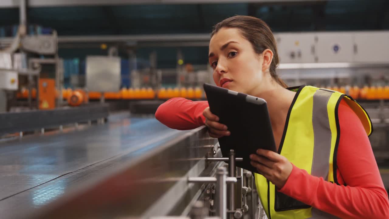 supervisora que utiliza una tableta digital cerca de la línea de producción