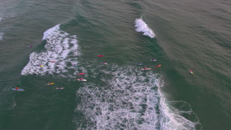 Luftaufnahme-Mit-Blick-Auf-Eine-Gruppe-Von-Zangen-Auf-Brettern,-Die-Während-Einer-Morgendlichen-Trainingseinheit-Mit-Wassersicherheit-Am-Beliebten-Mermaid-Beach-Gold-Coast-QLD-Australien-Im-Meer-Paddeln