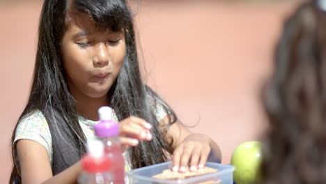 in school, girl eating lunch from container, enjoying meal during break