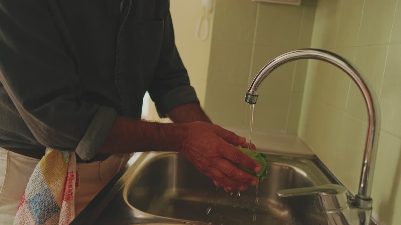 Washing lettuce in the kitchen sink