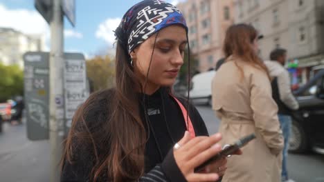 young woman using smartphone in city street