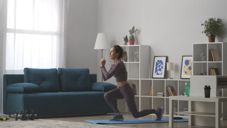 fitness practice at home young woman is squatting and jumping in living room sporty and active lifestyle caring about body shape