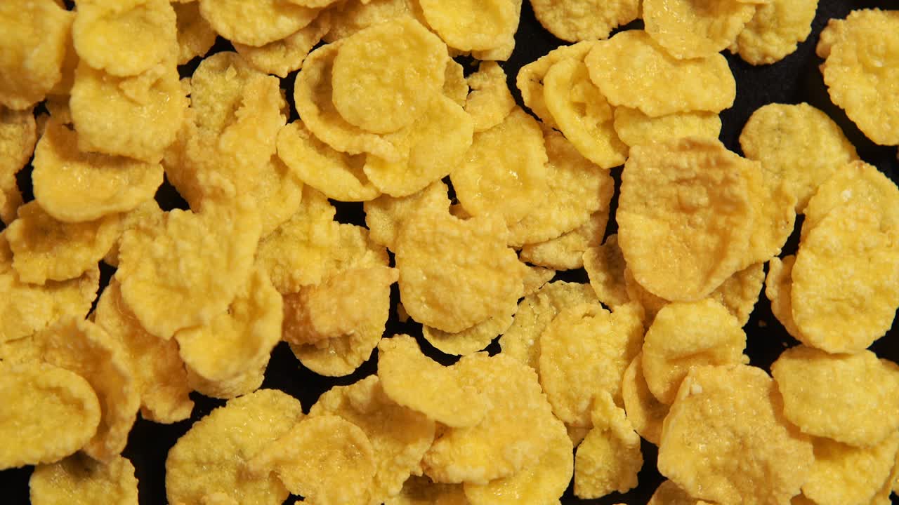 Fiocchi di mais dolci stanno ruotando sullo sfondo nero