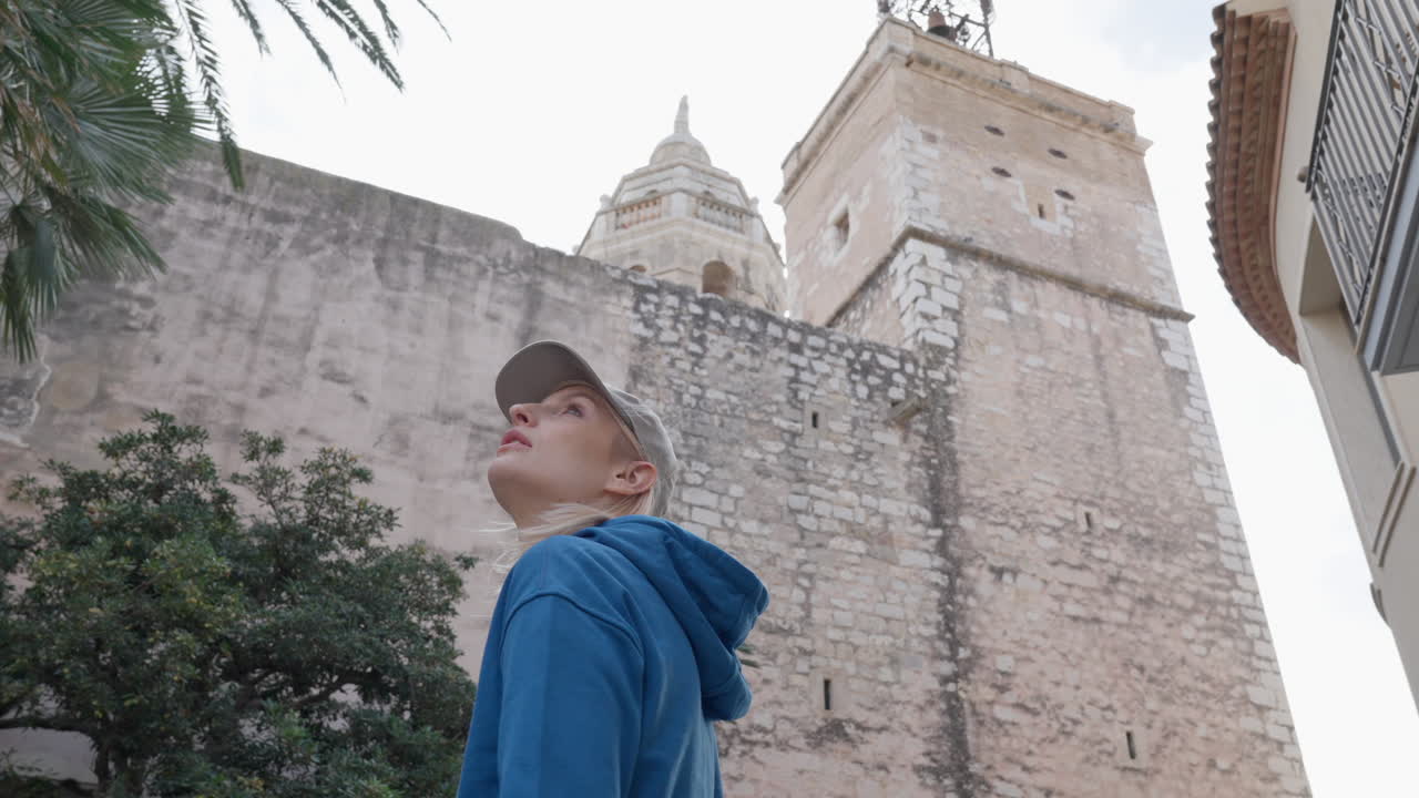 Tourist student girl observing a grand church old cathedral in Europe, sightseeing travel walk low angle point