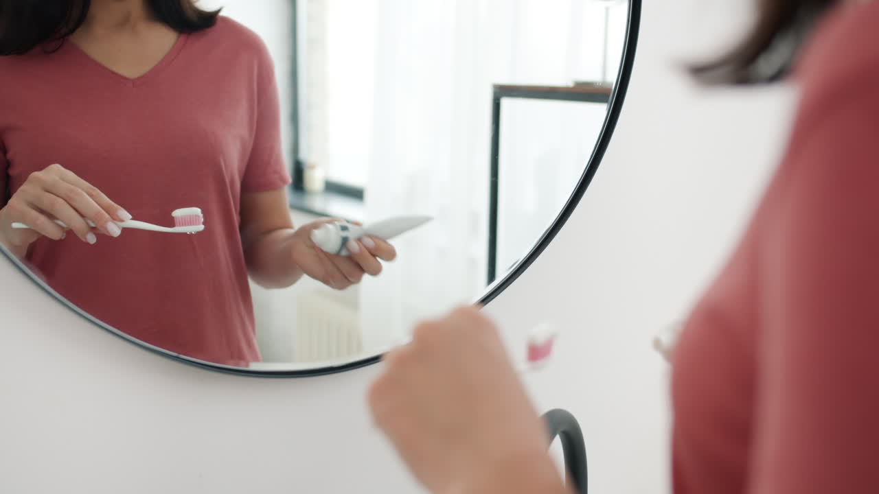Mujer cepillándose los dientes en el baño