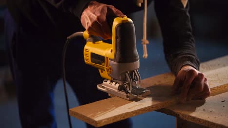 man using jigsaw to cut wood