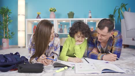 madre y padre hacen los deberes de sus hijos escribiendo y leyendo en casa, ayudan.