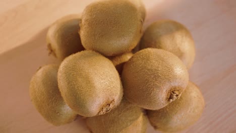 pile of exotic kiwifruits rotating on a wooden surface, macro shot