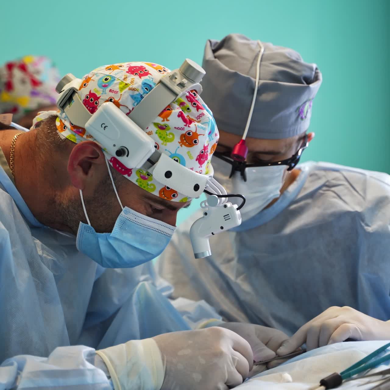 Experienced surgeons work carefully and scrupulously at operation. Doctors bend low over the patient to use tools