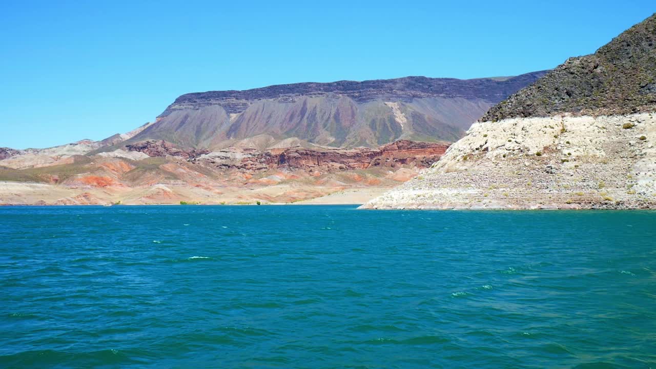 Lake Mead bathtub ring with red rock mountains in the background on calm water