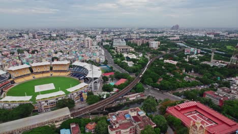chepauk railway station with local train and m. a. chidambaram stadium at victoria hostel road, pwd estate, chepauk, triplicane, chennai, tamil nadu, india. day time, push back, drone shot, 4k.