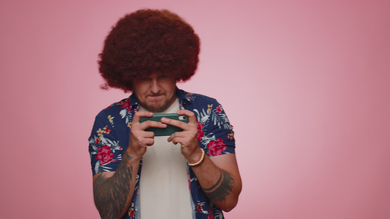 un turista adicto y divertido, preocupado, jugando con entusiasmo a videojuegos de carreras en su teléfono móvil