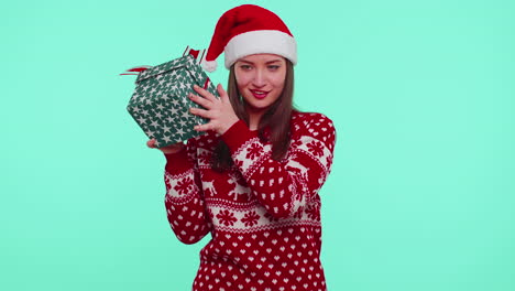 Funny-girl-wears-Christmas-holiday-sweater-received-present,-interested-in-what-inside-gift-box