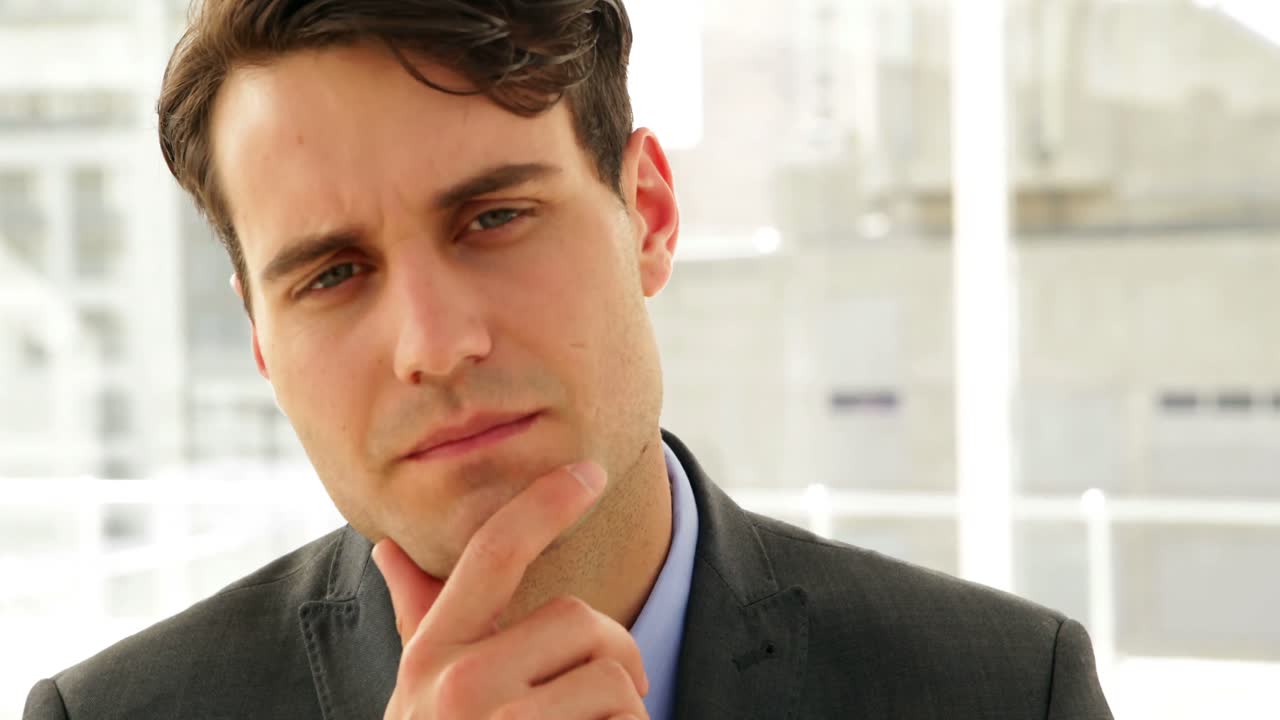 hombre de negocios mirando pensativo a la cámara