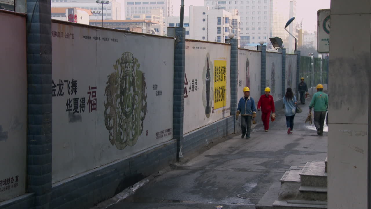 los trabajadores de una fábrica china caminan a casa por un callejón