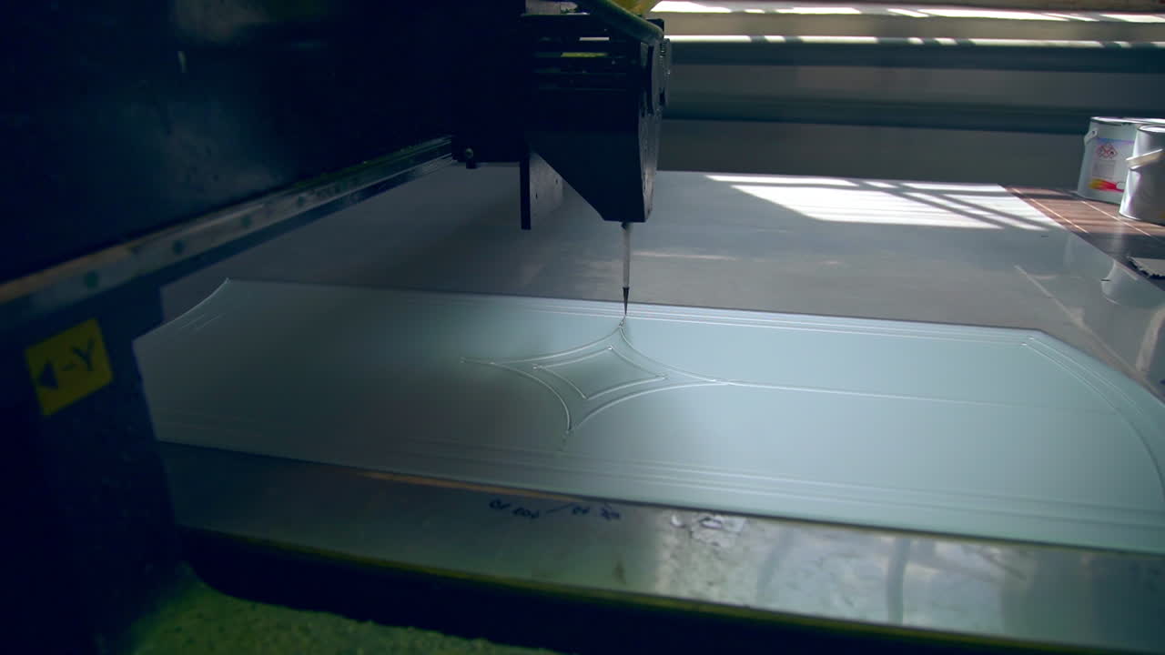 Special equipment for making décor at glass door. Automated machine moves leaving the picture on the glass surface.