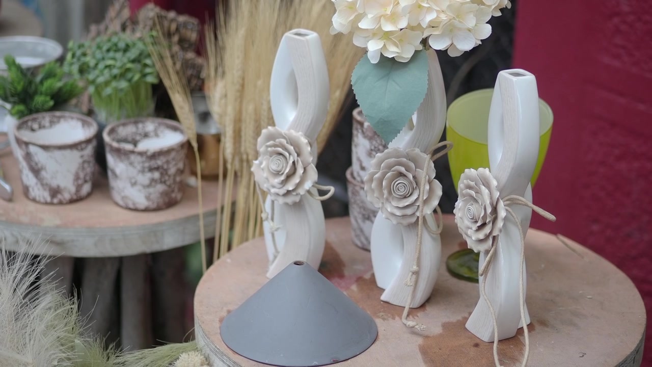 Vasos de cerâmica decorativos com detalhes florais em exibição.