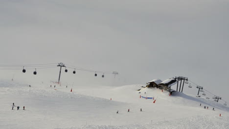 Time-lapse-of-ski-lifts-and-skiers-in-Meribel-in-the-French-Alps,-with-cloud-below-the-lifts