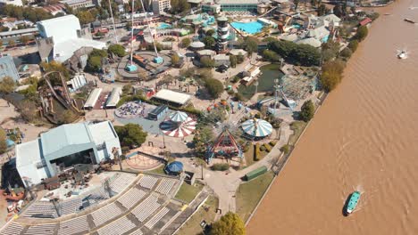 Boat-Sailing-At-Lujan-River-With-El-Octogono-Stage-An-Amphitheatre-At-Costa-Park-In-Tigre,-Buenos-Aires,-Argentina