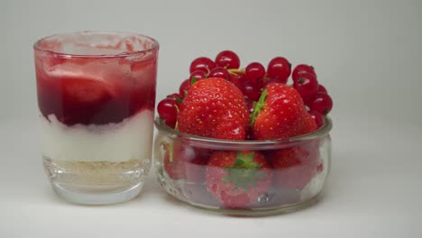 Strawberries-And-Grapes-In-A-Glass-Bowl-Together-With-Delicious-Strawberry-Shake-In-A-Turntable---Close-Up-Shot