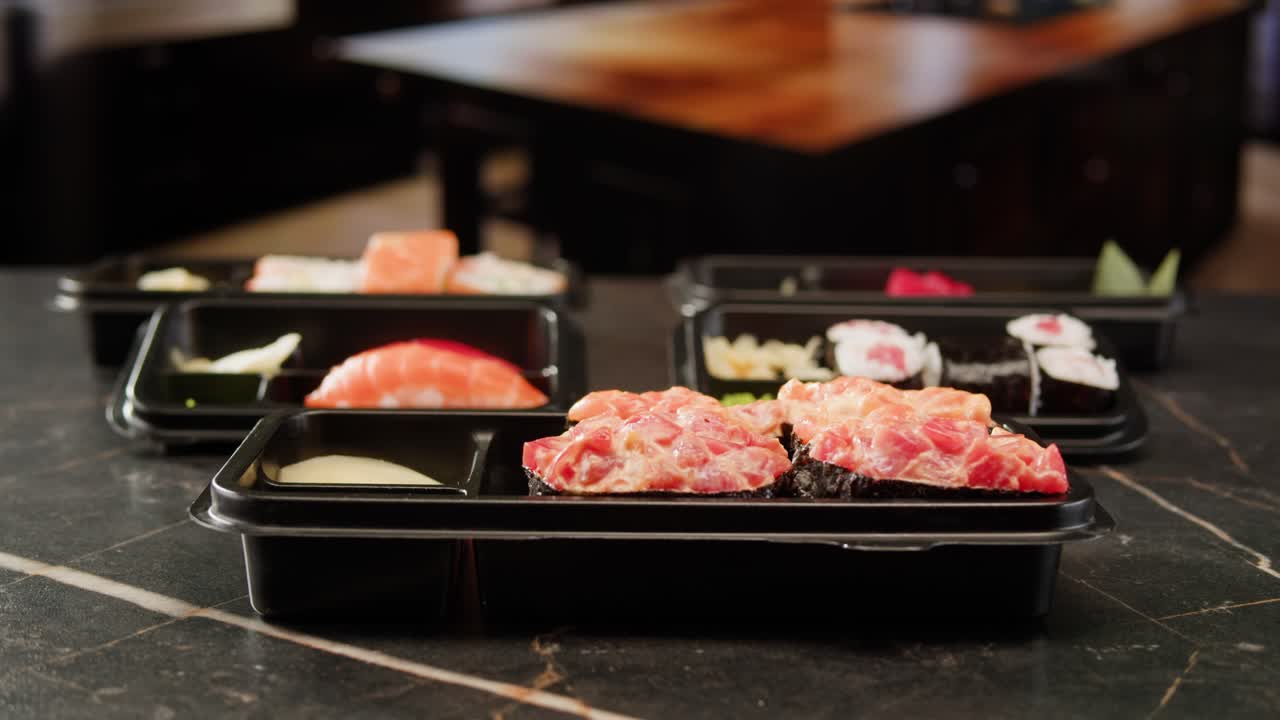Hand placing lid on takeout sushi container