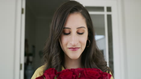 una mujer joven oliendo un montón de rojo hermoso