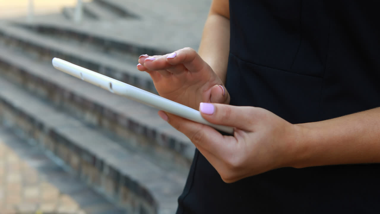 mujer de negocios usando tableta digital fuera del edificio de oficinas 4k