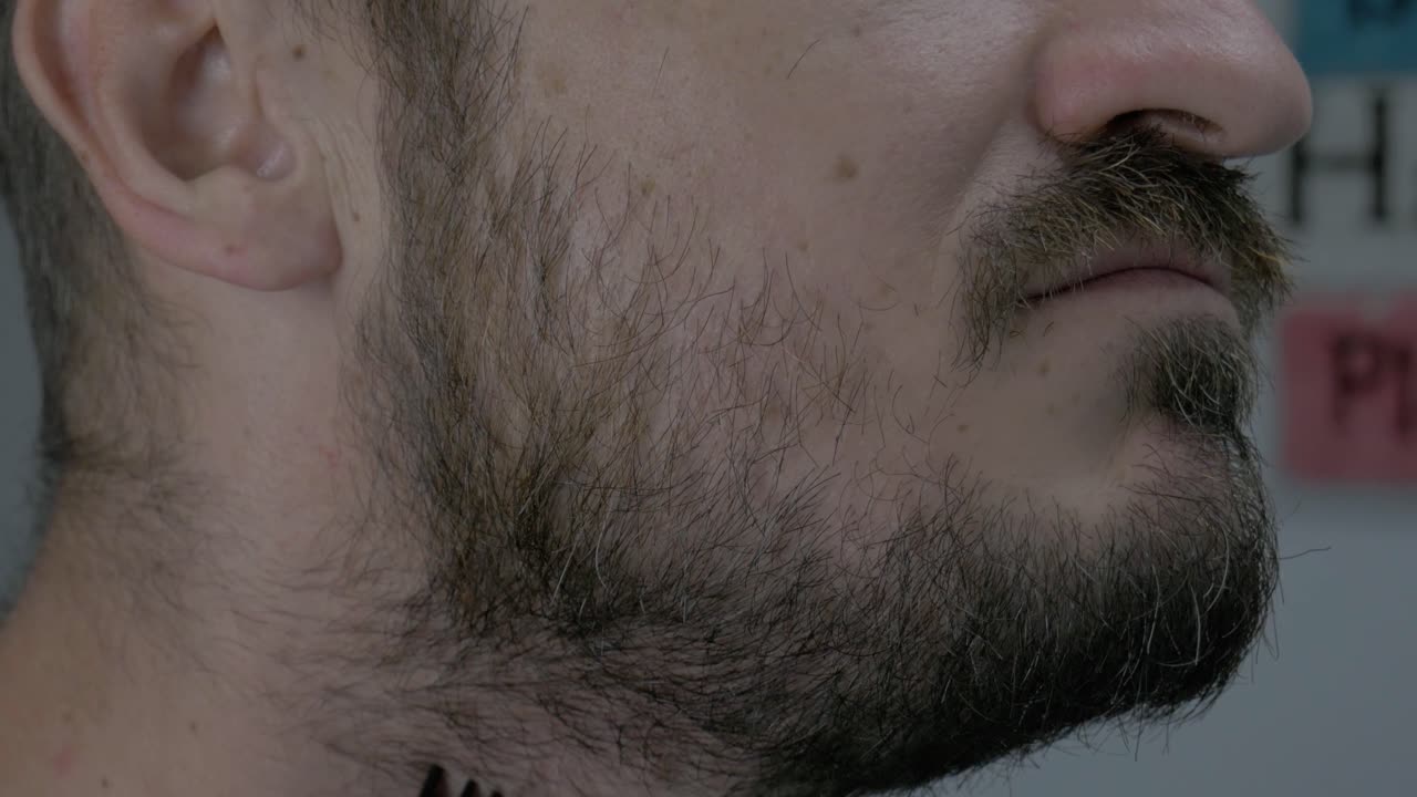 유럽인 으로 보이는 남자 는 부드럽게 보이기 위해 전기 면도기 로 얼굴 털 을 면도 하고 있다