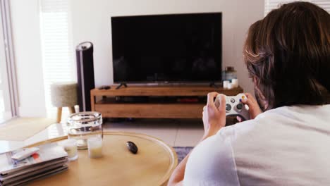 man playing video games in living room