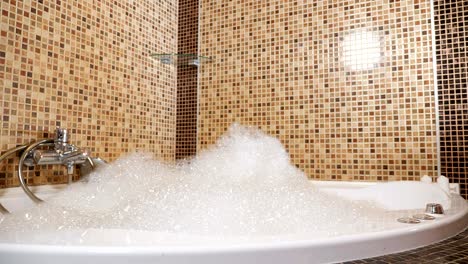 espuma blanca y suave en la bañera de agua caliente