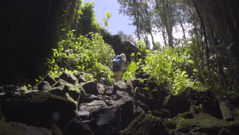 woman walking out of a cave in hawaii