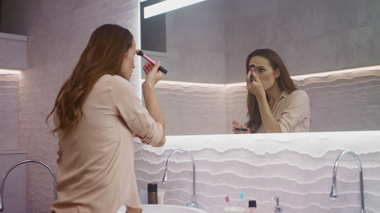 mujer de belleza haciendo maquillaje en el baño. mujer feliz haciendo maquillaje matutino.