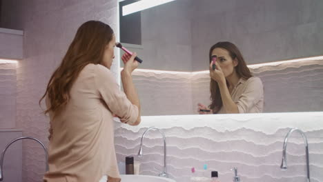 beauty woman doing makeup in bathroom. happy woman making morning makeup.