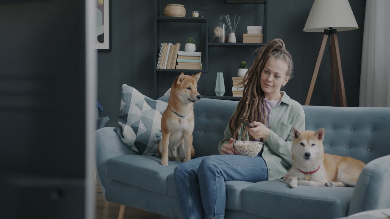 Woman Relaxing with Dogs and Popcorn in Front of TV