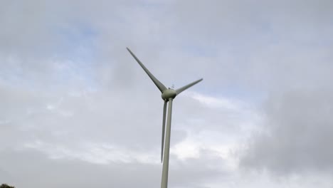 windmill spinning against a grey sky