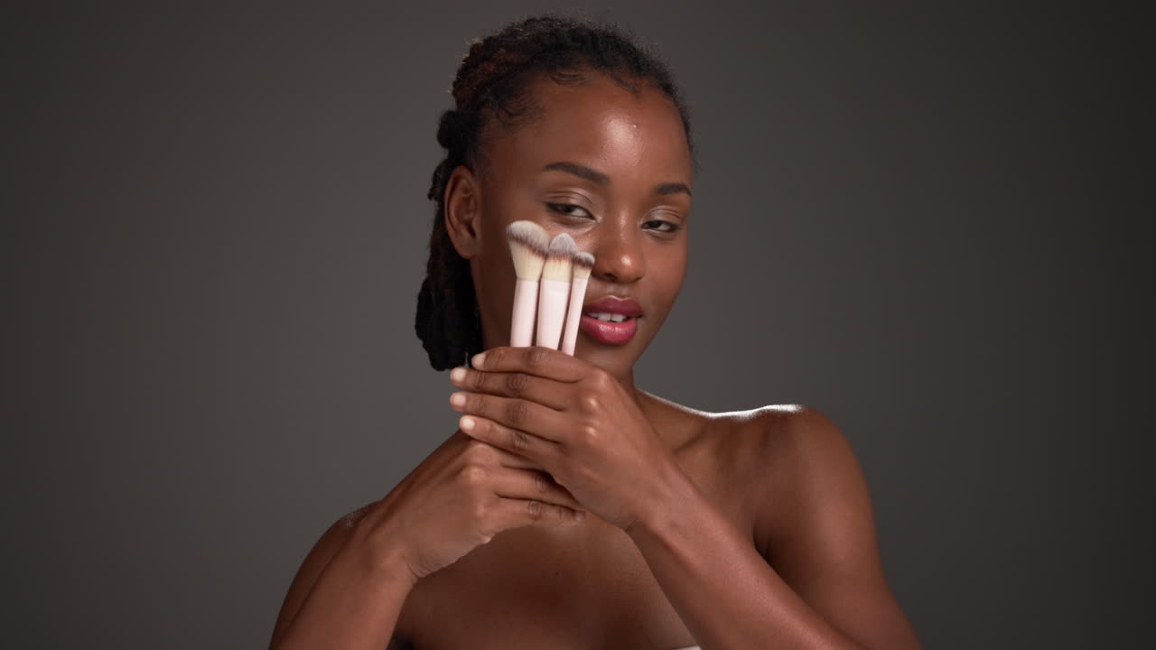Beautiful African American Woman with Makeup Brushes