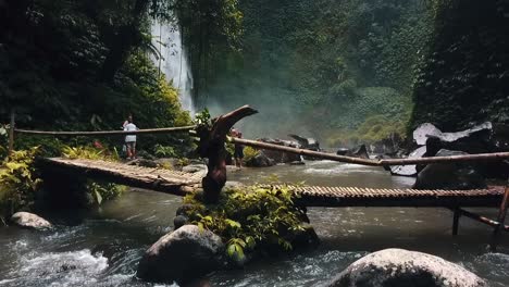 bali, spring 2020 in 1080 60p, daytime, cinematic drone flight a slow motion flight up tu down in front of a indigenous bridgea and waterfall in the background