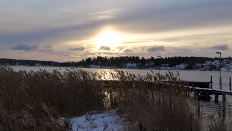 winter landscape with a lake and pontoon at the end of the day