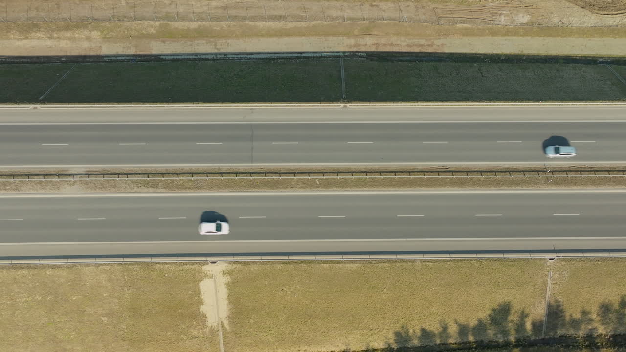 두 대의 자동차가 같은 방향으로 운전하고 있는 고속도로의 상단에서 아래로 보이는 모습, 거리로 분리되어 있습니다.